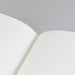 Close-up of premium recycled lined paper showing crisp ruled lines and smooth ivory pages, demonstrating superior paper quality for professional note-taking