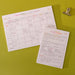 Two complementary content planning tools on a lime green background - an A4 monthly social media calendar grid layout and an A5 daily content planner page, both filled with handwritten notes. A gold bulldog clip visible in the corner. Pink and orange headers on white recycled paper showing coordinated design.