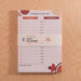 Daily planner showing B-Corp certification, 100% recycled paper badge and complete layout with to-do list and hourly schedule on wooden surface