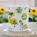 White ceramic mug with positive affirmations including "I am allowed to express myself" and "I make progress every day" in yellow and black hand-lettering, decorated with doodles of flowers and bees. Sunflowers visible in soft focus background.