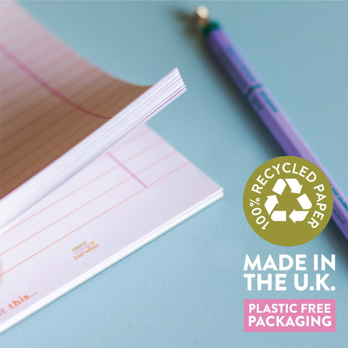 Close-up of the To Do List pad showing its recycled paper pages with pink lines, alongside badges highlighting "100% Recycled Paper", "Made in the U.K.", and "Plastic Free Packaging". A purple pen rests against a blue background.