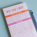 A filled To Do List pad showing business tasks like "Update LinkedIn" and "Contact agency" in the "Must Do Today" section, with longer-term tasks listed under "The Rest". The pad features orange and pink section headers with estimated time allocations next to each task.