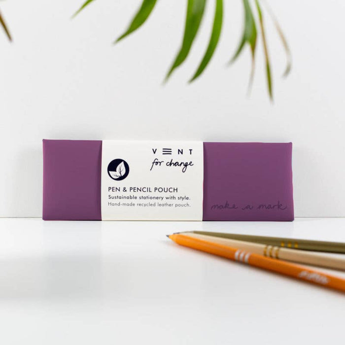 Purple recycled leather pen pouch by Vent for Change, featuring debossed design and sustainable stationery label, shown with pencils against white background with plant leaves